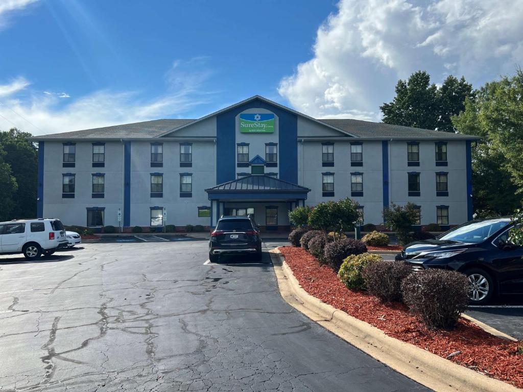 un gran edificio con coches estacionados en un estacionamiento en SureStay Hotel by Best Western Morganton, en Morganton