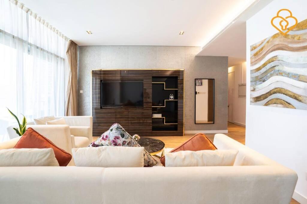 uma sala de estar com um sofá branco e uma televisão em Keysplease 2 BR minutes to Dubai Mall 408, City Walk em Dubai