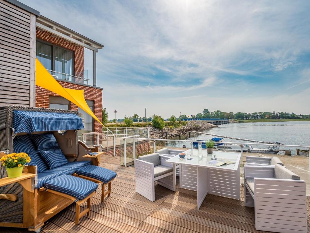 a deck with chairs and a table on a boat at Ferienappartement MEERZEIT in Mursewiek
