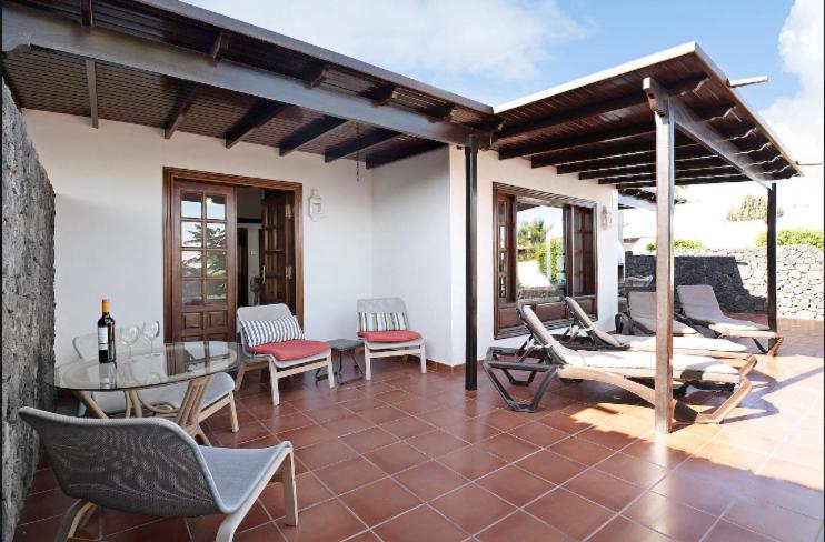 a patio with a table and chairs on a house at Villa Las Palmeras in Playa Blanca