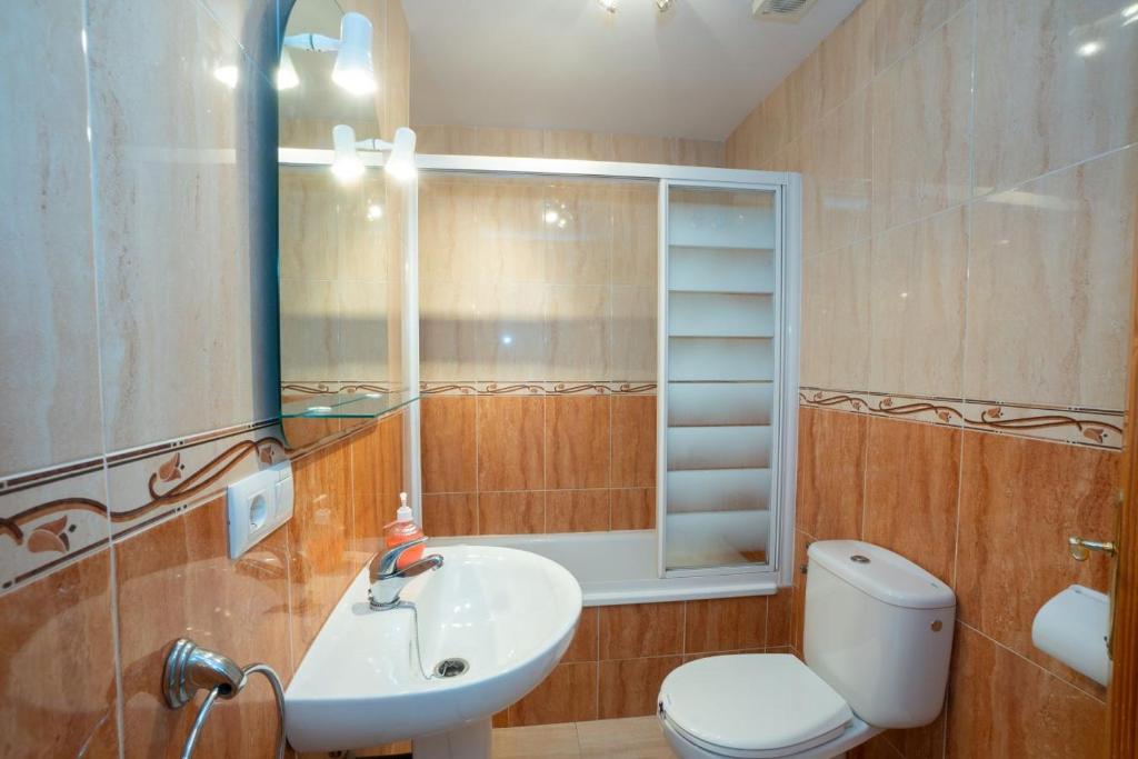łazienka z umywalką, toaletą i lustrem w obiekcie CAPISTRANO VILLAGE 15 Menyber w mieście Nerja