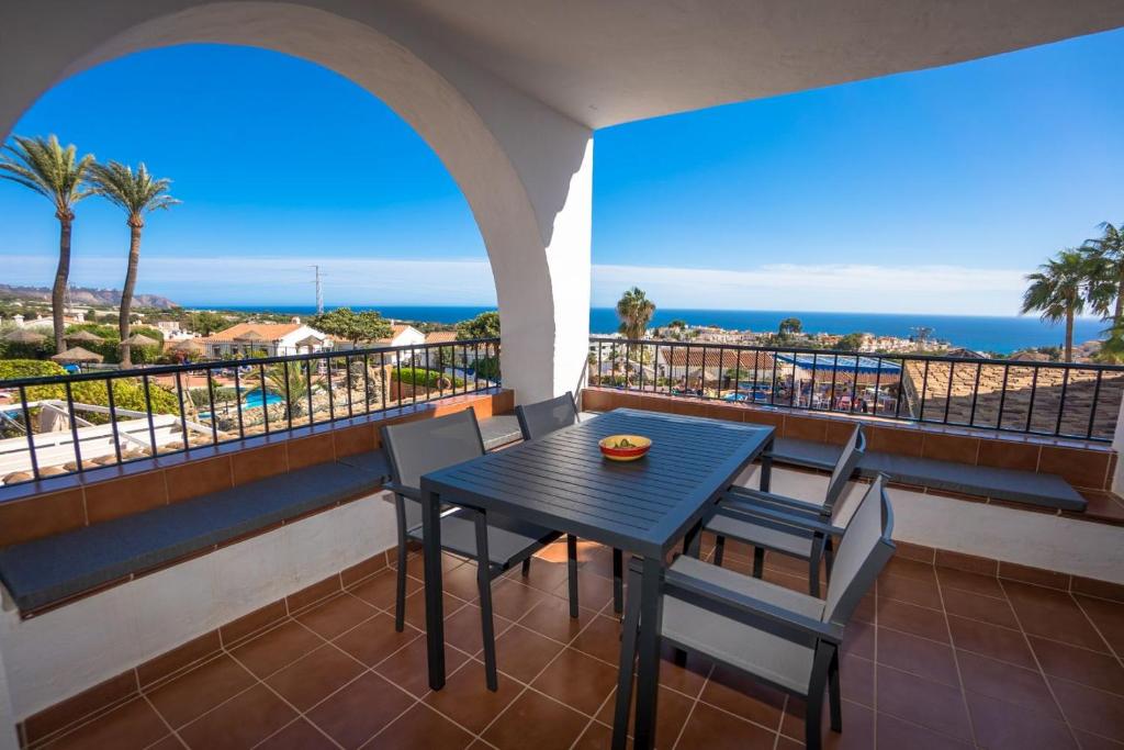 stół i krzesła na balkonie z widokiem na ocean w obiekcie CAPISTRANO VILLAGE 15 Menyber w mieście Nerja