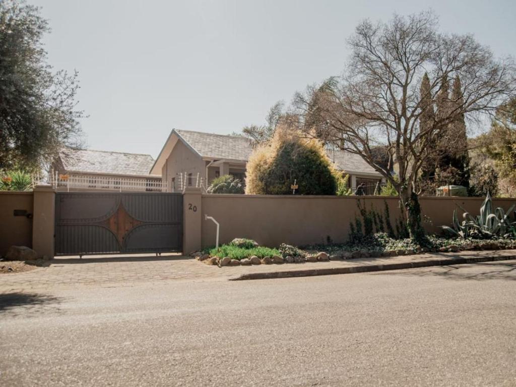 una casa con una valla delante de una entrada en La Casa Guest House, en Bloemfontein