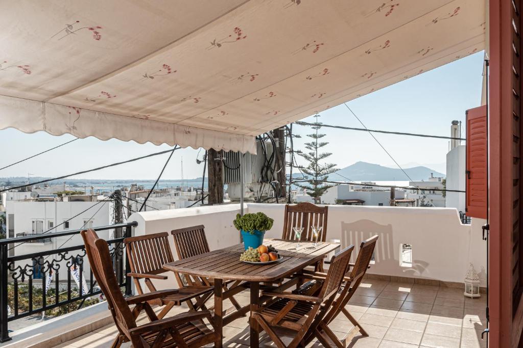 stół i krzesła na balkonie z widokiem w obiekcie Optasia Naxos Center 2 bedroom New Apartment w mieście Naksos