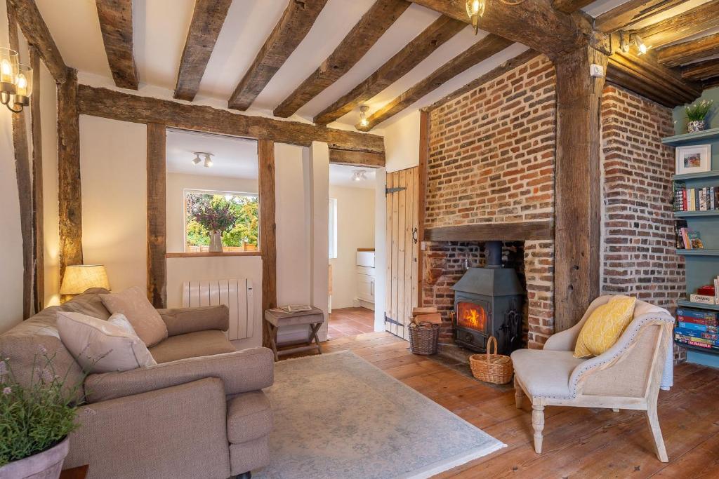 a living room with two couches and a fireplace at Angelic 16th Century cottage in key Constable village - Bear Cottage in Nayland
