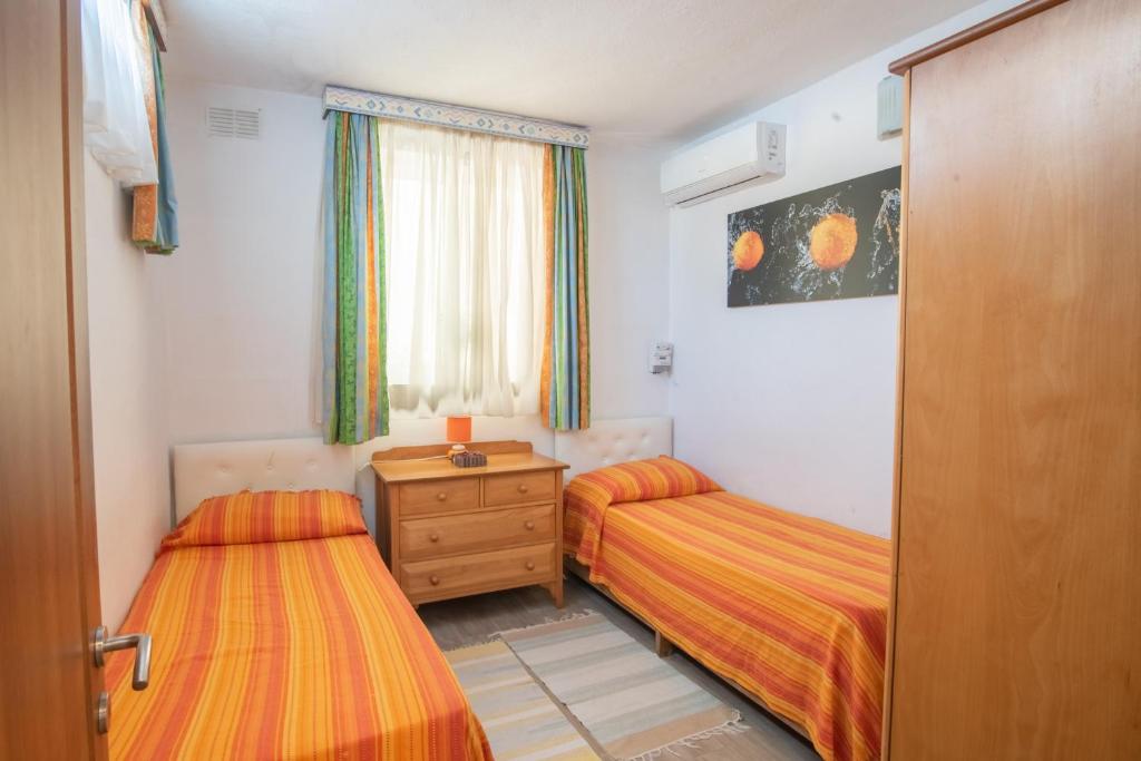 a bedroom with two beds and a wooden door at Central villa flatlet with pool - free parking and WiFi in Lija