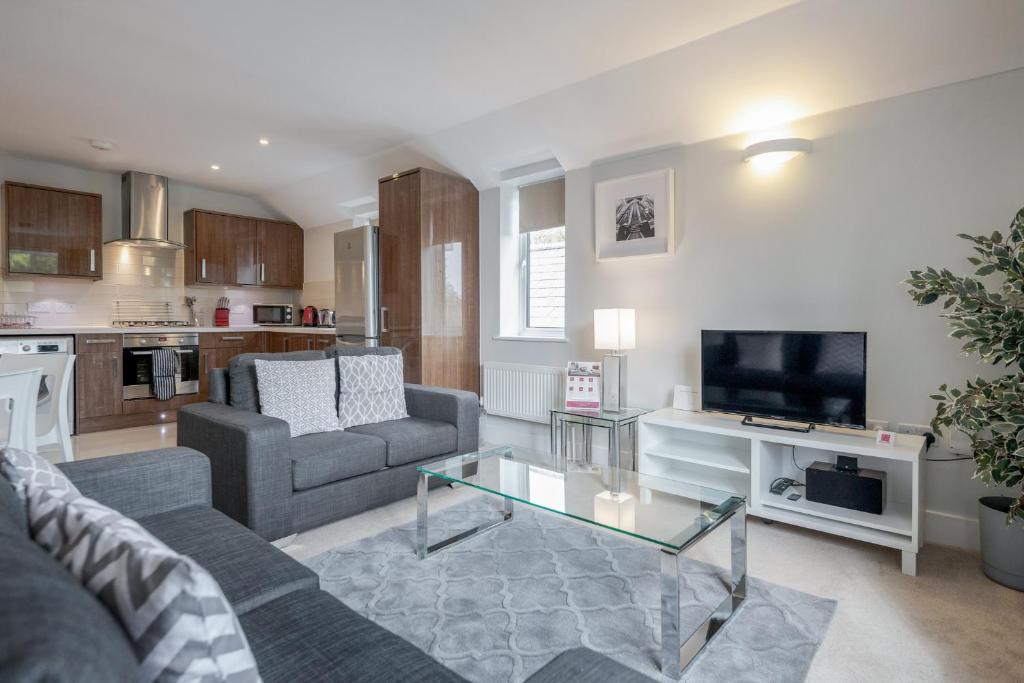 a living room with a couch and a tv at Roomspace Serviced Apartments - Nevis Court in Surbiton