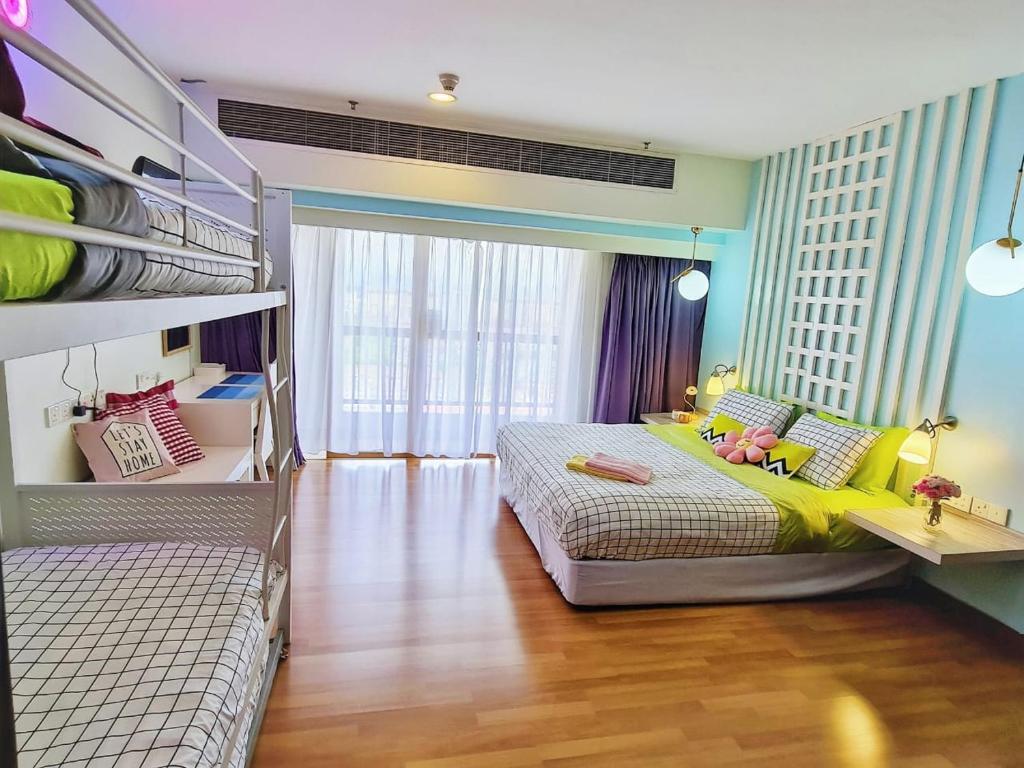 Exclusive Family Suites 5-6 Pax @ Sunway Pyramid في بيتالينغ جايا: غرفة نوم بسريرين وبنت راقدة على السرير
