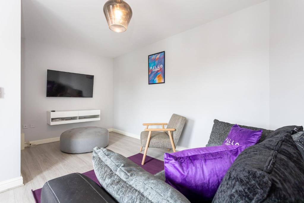 a living room with a couch and a tv at Pillo Rooms Serviced Apartments - Trafford in Manchester