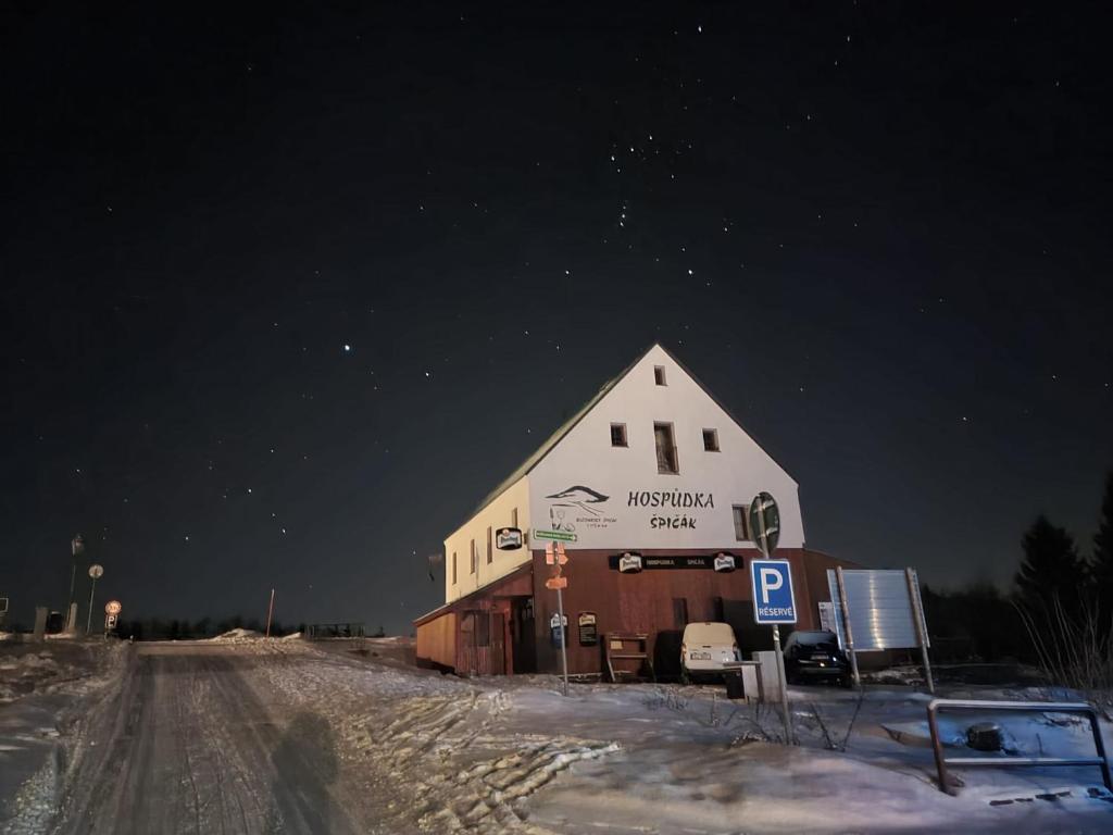 Une grande grange dans la neige la nuit dans l'établissement Penzion Kubis, à Boží Dar