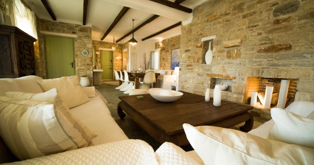 a living room with couches and a stone wall at Dream Villa Santa Maria in Santa Maria