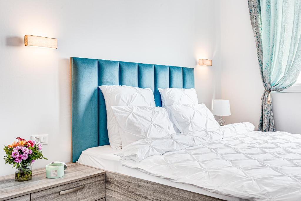a bedroom with a large bed with a blue headboard at ARI Brownie Apartment in Arad