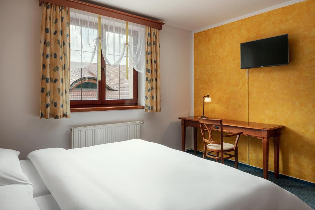 Postel nebo postele na pokoji v ubytování Golf & Spa Kunětická Hora