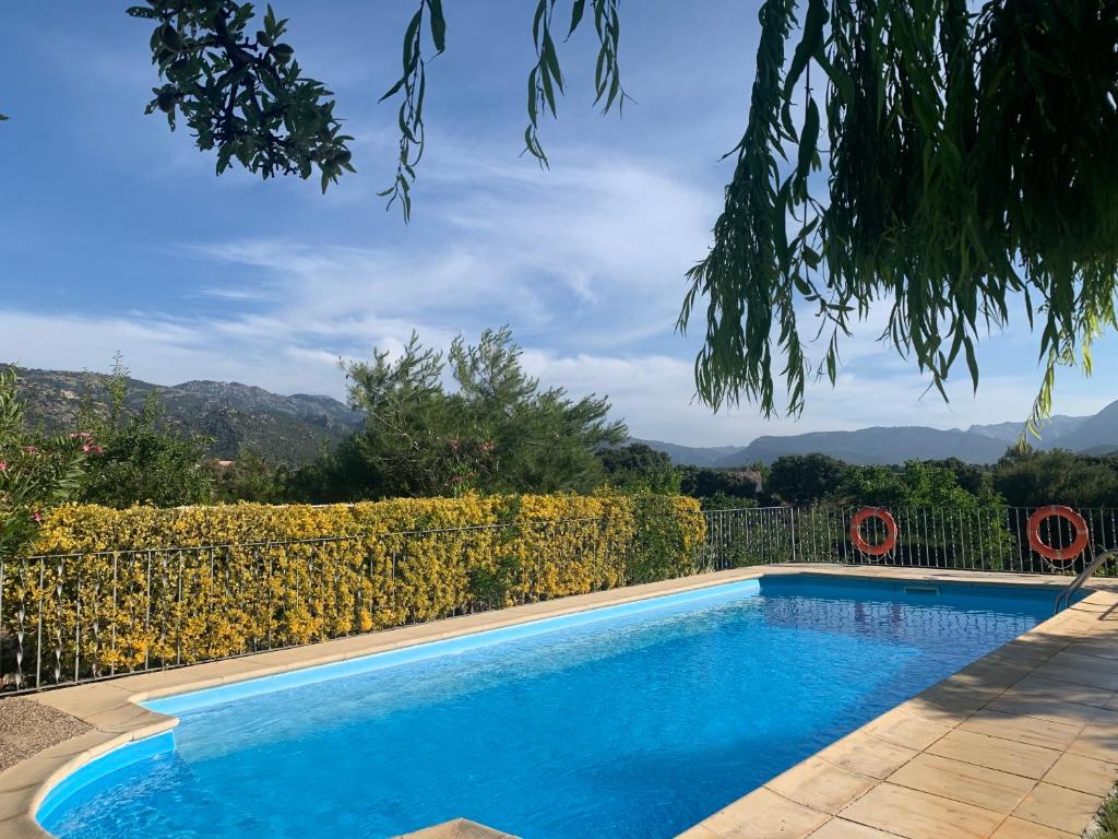 une piscine avec une clôture et des montagnes en arrière-plan dans l'établissement Cabañas Cortijo el Helao, à Pozo Alcón