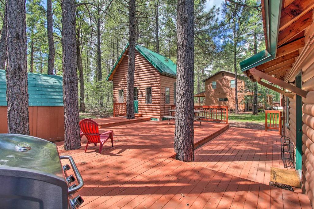 una terraza de madera con una cabaña en el bosque en Woodsy Pinetop Cabin and Deck and Separate Casita, en Pinetop-Lakeside