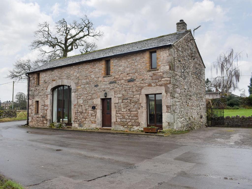 an old stone building in a parking lot at Primrose Bank in Tirril