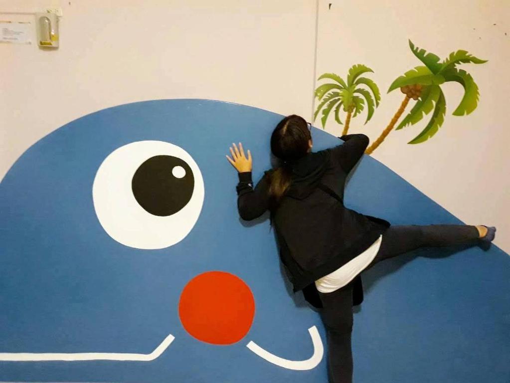 a woman is sitting on top of a p logo at 7-1 House Homsetay in Hualien City