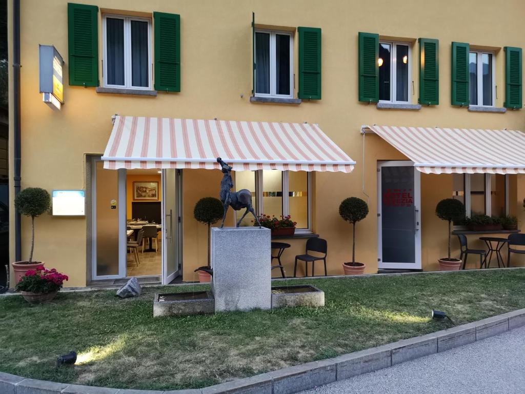 a building with a striped awning in front of it at Hotel Elvezia in Lavorgo