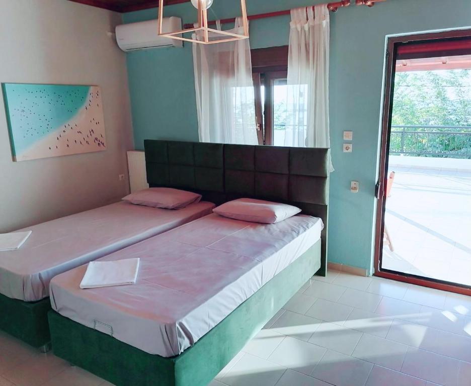 una camera da letto con un grande letto con una grande finestra di KIRKOS “PORTO” a Samotracia