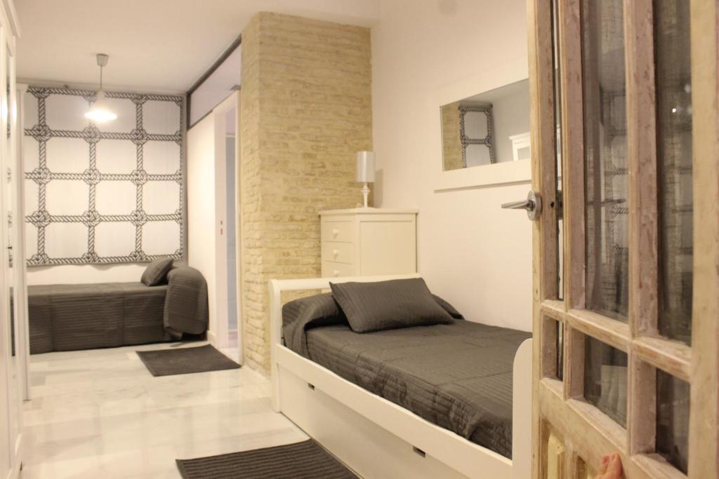 mała sypialnia z łóżkiem i oknem w obiekcie Amazing Sevilla Apartamento w Sewilli