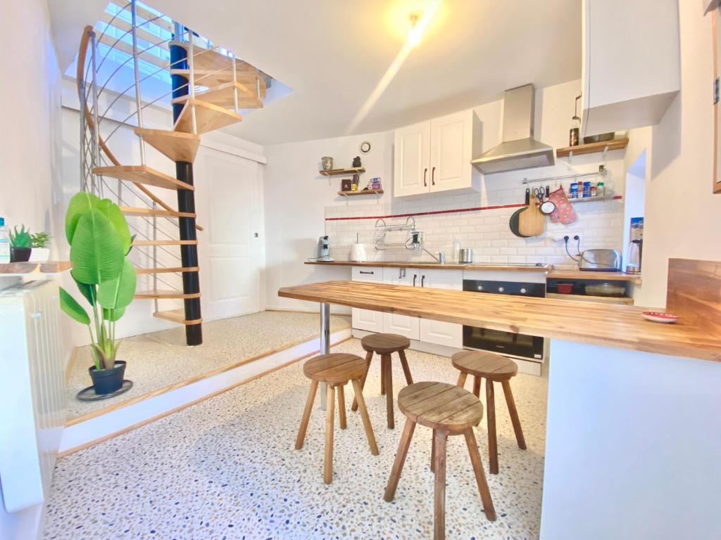 普瓦捷的住宿－- Le Lys - Magnifique maisonnette avec terrasse，厨房配有木桌和凳子