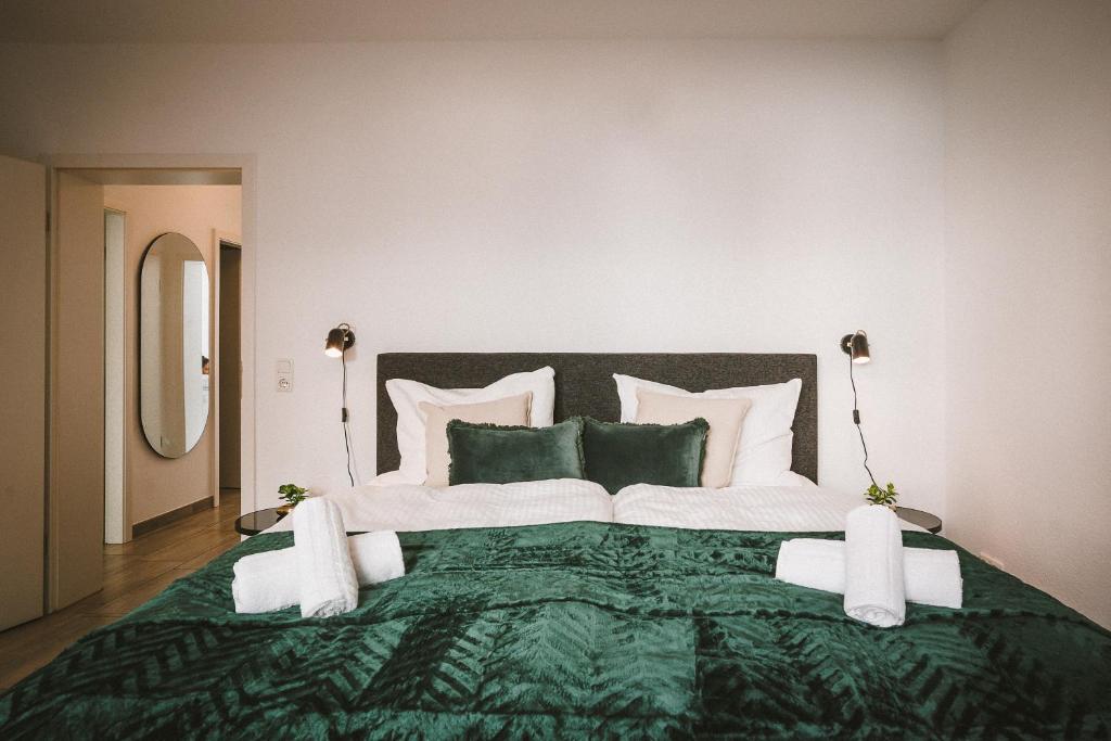 a large green and white bed in a bedroom at Sadebo Apartments Lübeck mit Terrasse oder Balkon in Lübeck