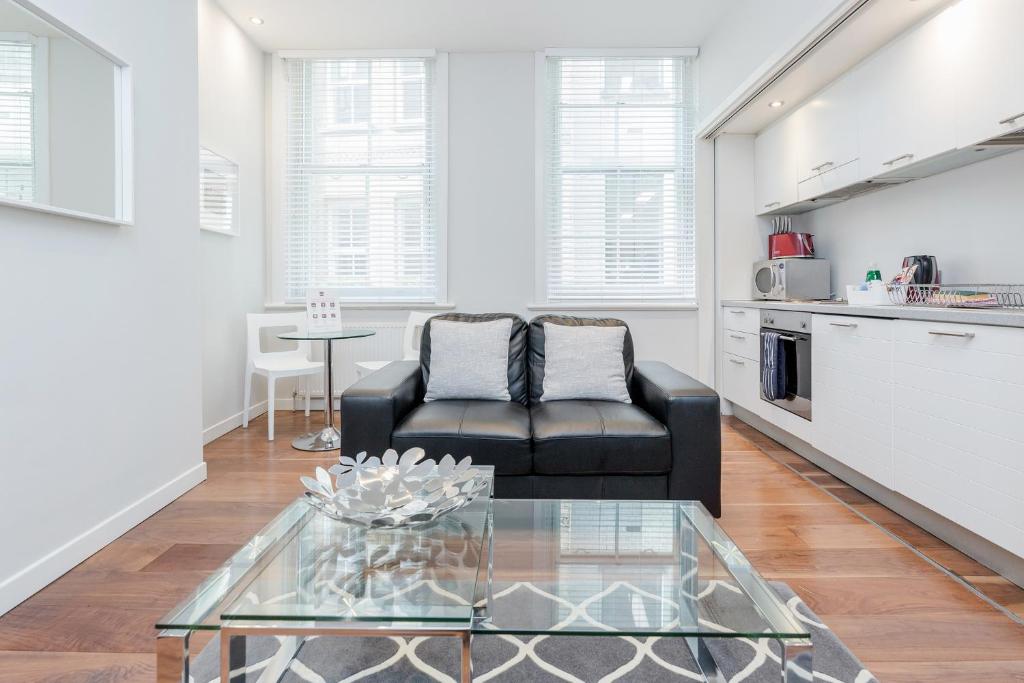 a living room with a couch and a glass table at Roomspace Serviced Apartments - Sterling House in London