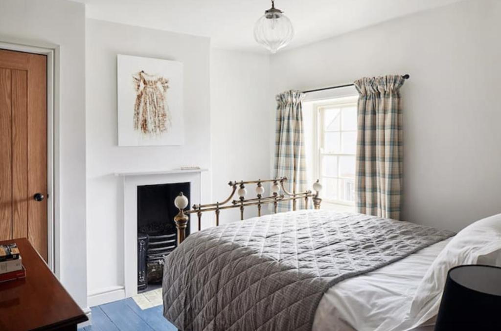 a bedroom with a bed and a fireplace at Parva House (Holt) in Holt
