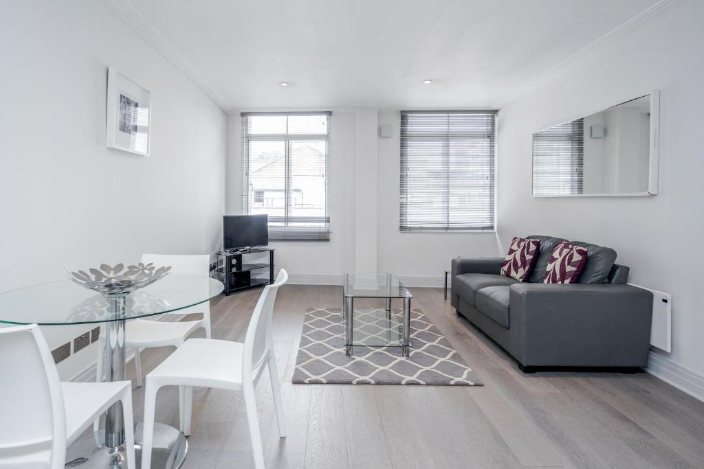 a living room with a couch and a glass table at Roomspace Serviced Apartments - River House in London