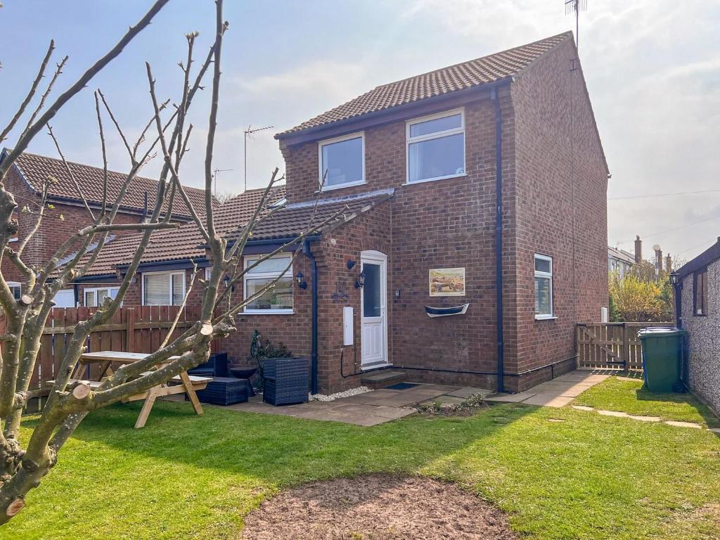 a brick house with a tree in the yard at Carr Naze House in Filey