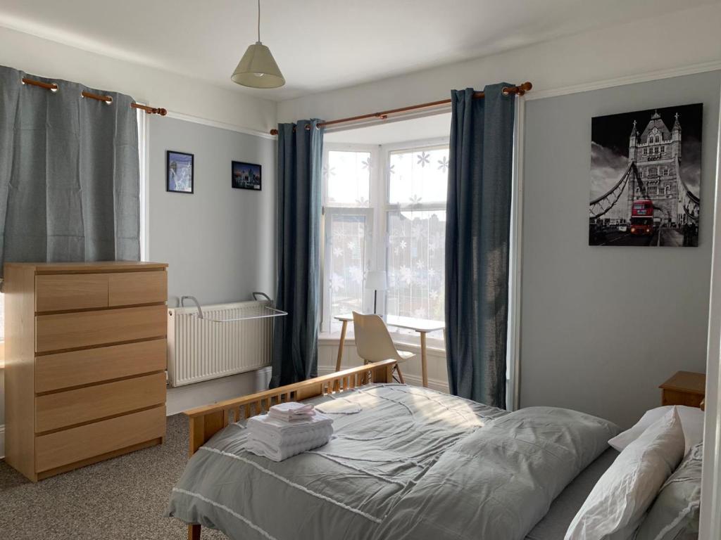 樸次茅斯的住宿－Cosy 2 bed flat in Baffins，一间卧室配有一张床、一个梳妆台和一扇窗户。