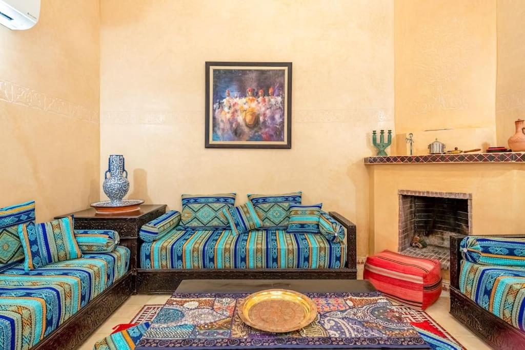 uma sala de estar com dois sofás e uma lareira em Riad Anir em Marraquexe
