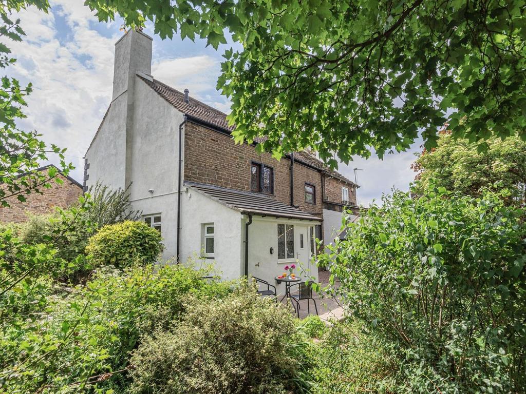 an old white house with a tower on top of it at Lane Ends Cottage in Disley