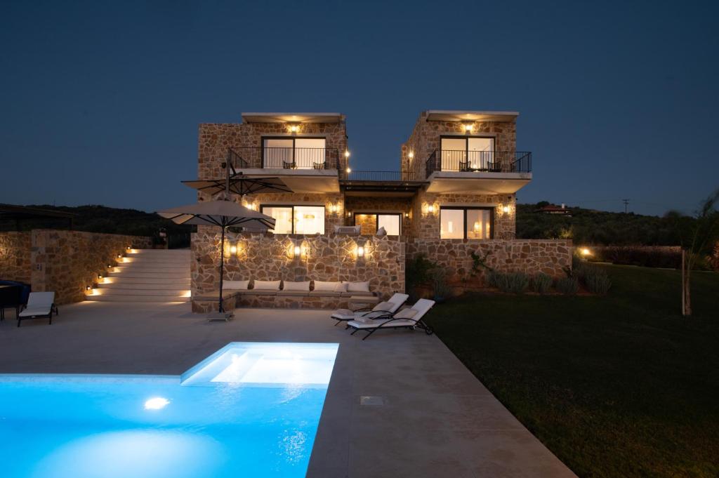 ein Haus mit Pool davor in der Nacht in der Unterkunft Family & Golf VILLA LAGUNA TOWERS Gialova Navarino in Gialova