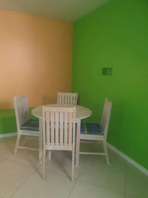 a table and chairs in a room with green walls at Corinth Convinced in Gros Islet