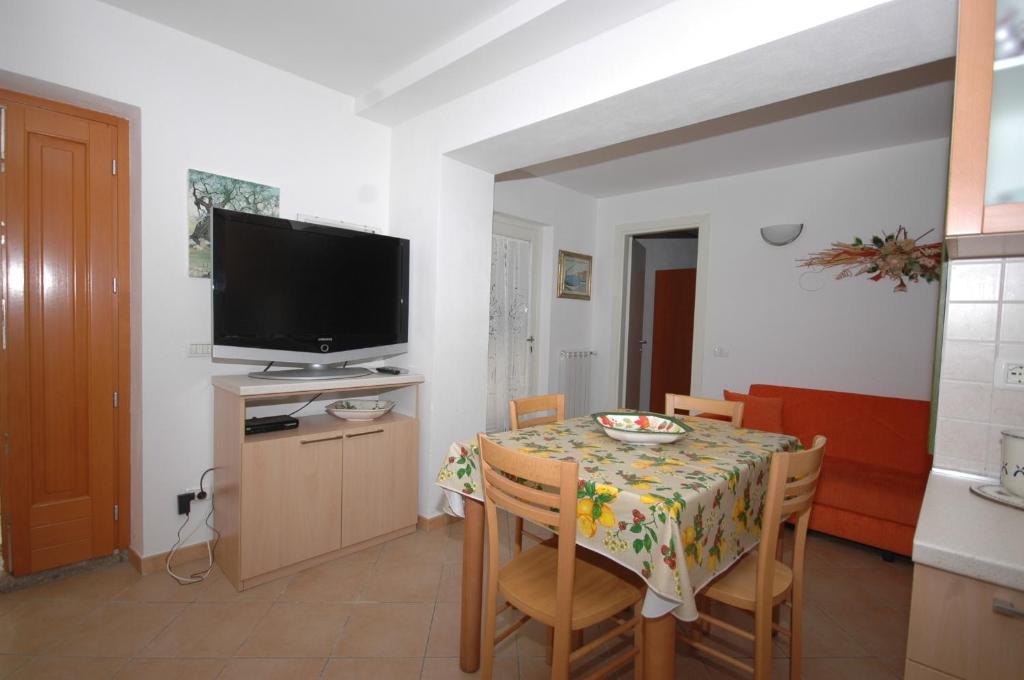 une salle à manger avec une table, des chaises et une télévision dans l'établissement Pozzo al Moro, à Marina di Campo