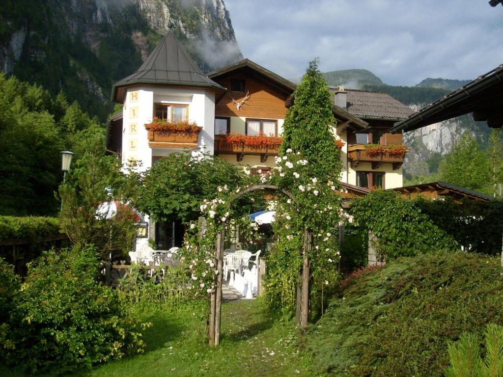 a house with flowers in front of it at Pension Hirlatz in Hallstatt