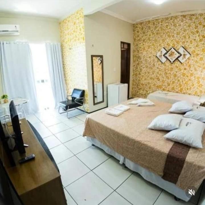 a bedroom with a large bed and a television at Hotel São Francisco in Tianguá