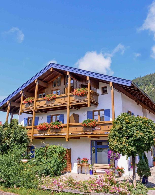 a house with a balcony with flowers on it at Gästehaus Hanna Teifel in Reit im Winkl