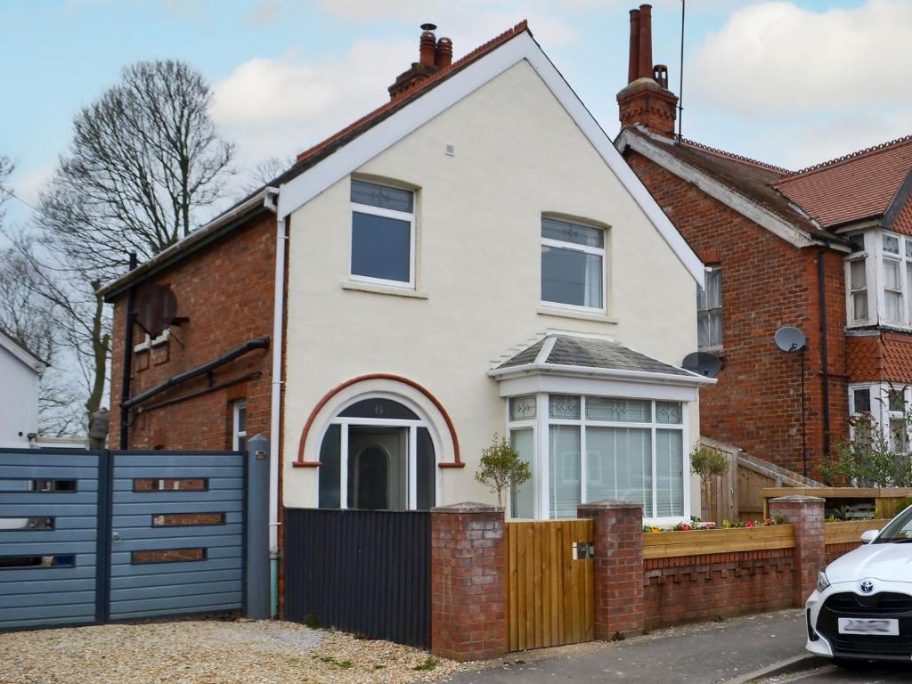 a white house with a blue fence at Nalas Cottage in Skegness