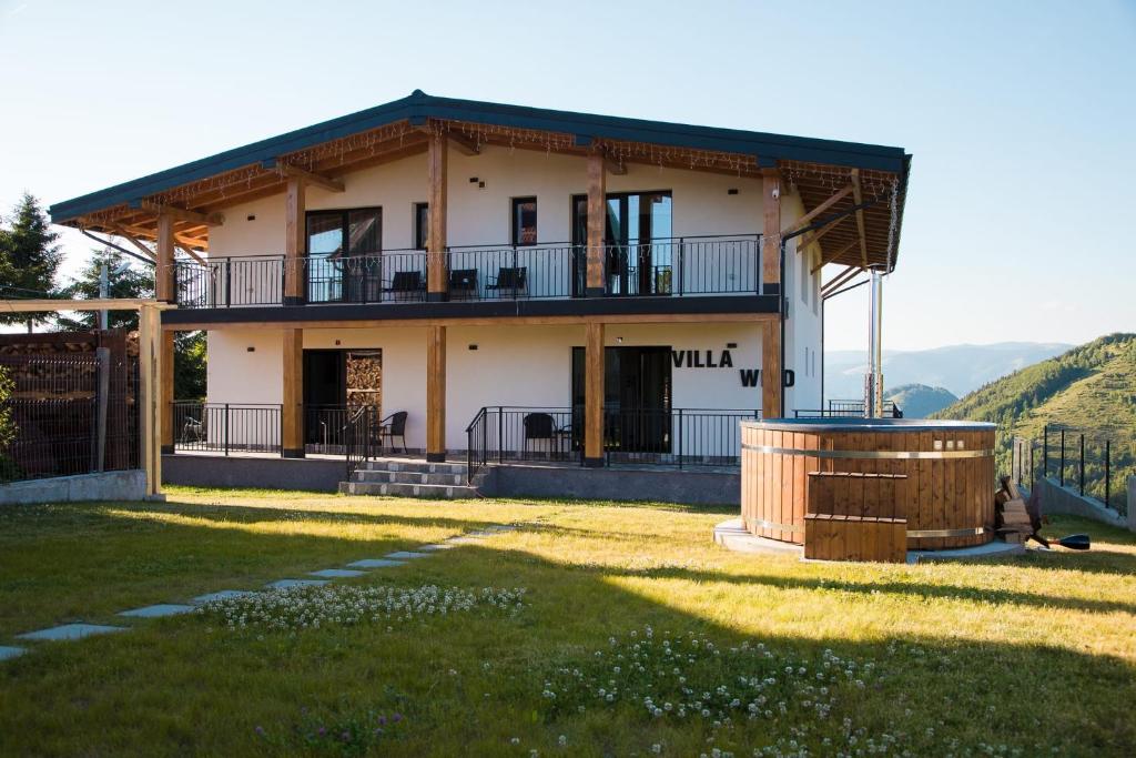 een huis met een balkon en een hot tub bij Villa Wild Rooms in Jieţ