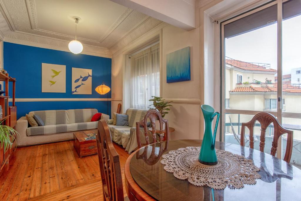 sala de estar con mesa y sofá en The Bleu Lisbon Flat, en Lisboa