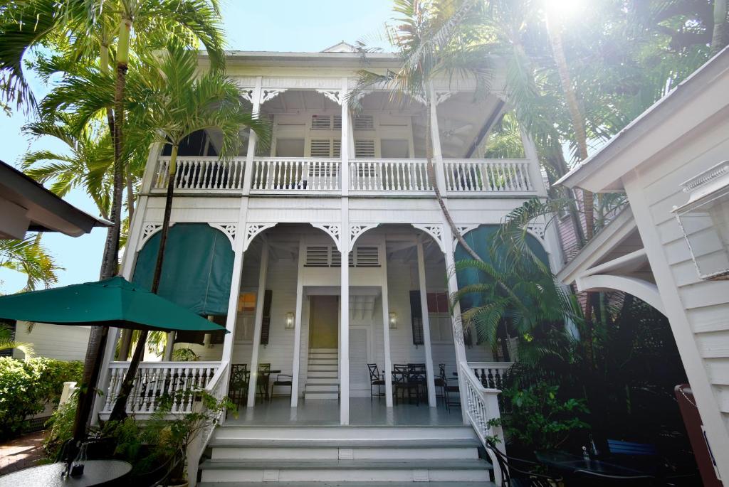 a white house with palm trees in front of it at Simonton Court Historic Inn & Cottages in Key West