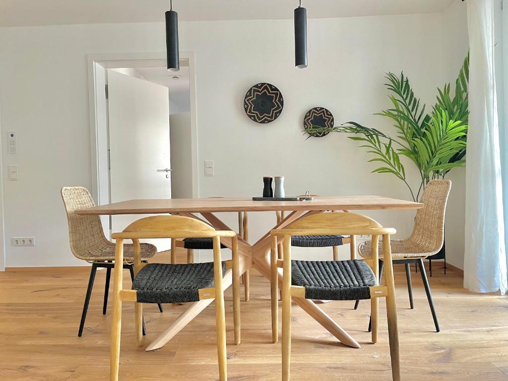 a dining room table with chairs and a wooden table at Hochfelder Traumsuite am Tegernsee in Tegernsee