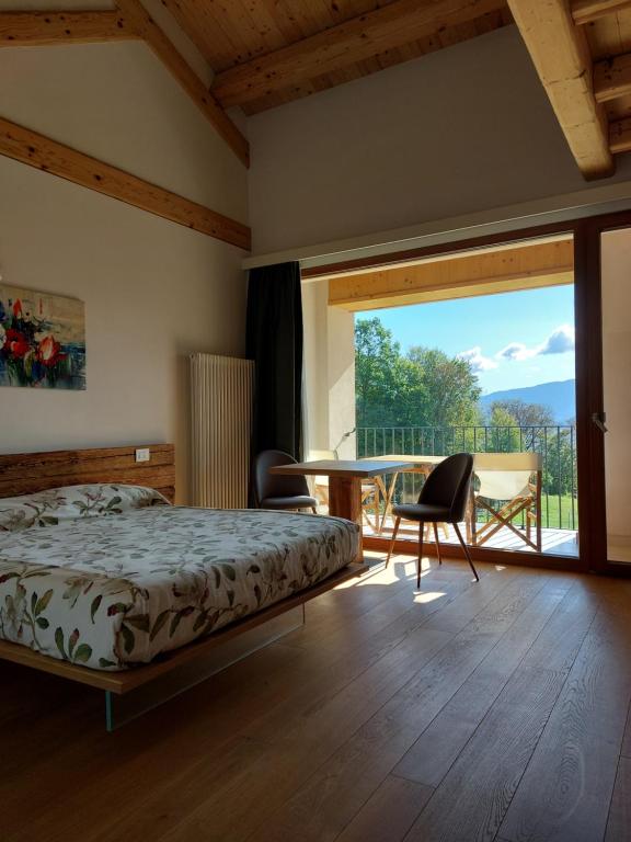 a bedroom with a bed and a table and chairs at La casa di Maia - Alloggio Agrituristico in Pedavena