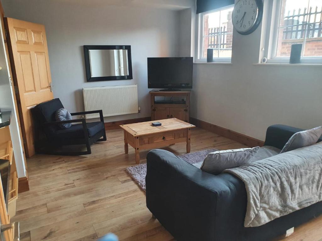 a living room with a couch and a coffee table at Spacious fully furnished 2 bed appartment next to BAE, in Barrow in Furness