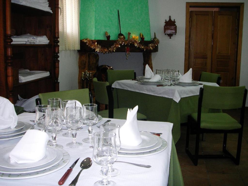 uma sala de jantar com mesas com pratos e copos de vinho em Hotel Rural El Cuco em Ribatajadilla