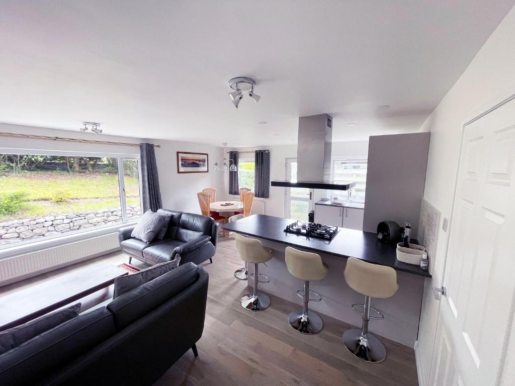 a kitchen and living room with a couch and a table at Matara House Holiday Home in Inverness