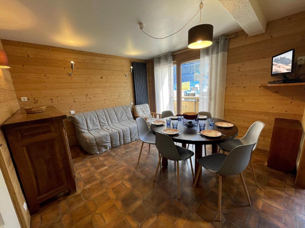 un salon avec une table, des chaises et un canapé dans l'établissement Neige et Roc 2 - Appartement 2 chambres centre, à La Clusaz