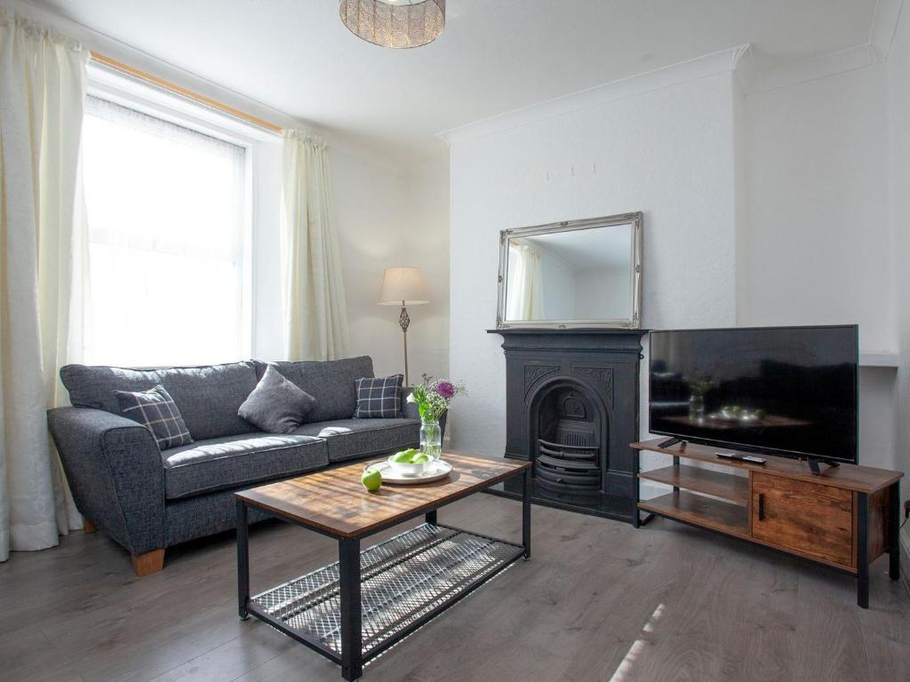 a living room with a couch and a fireplace at Suzies Pad in Torquay